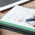 Mano marcando una fecha en un calendario
